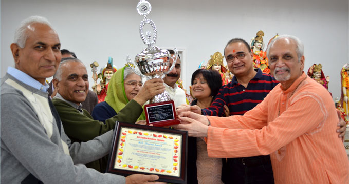 Community members presenting the M D Sharma Award trophy and plaque at Sri Radha Krishna Temple, Toronto
